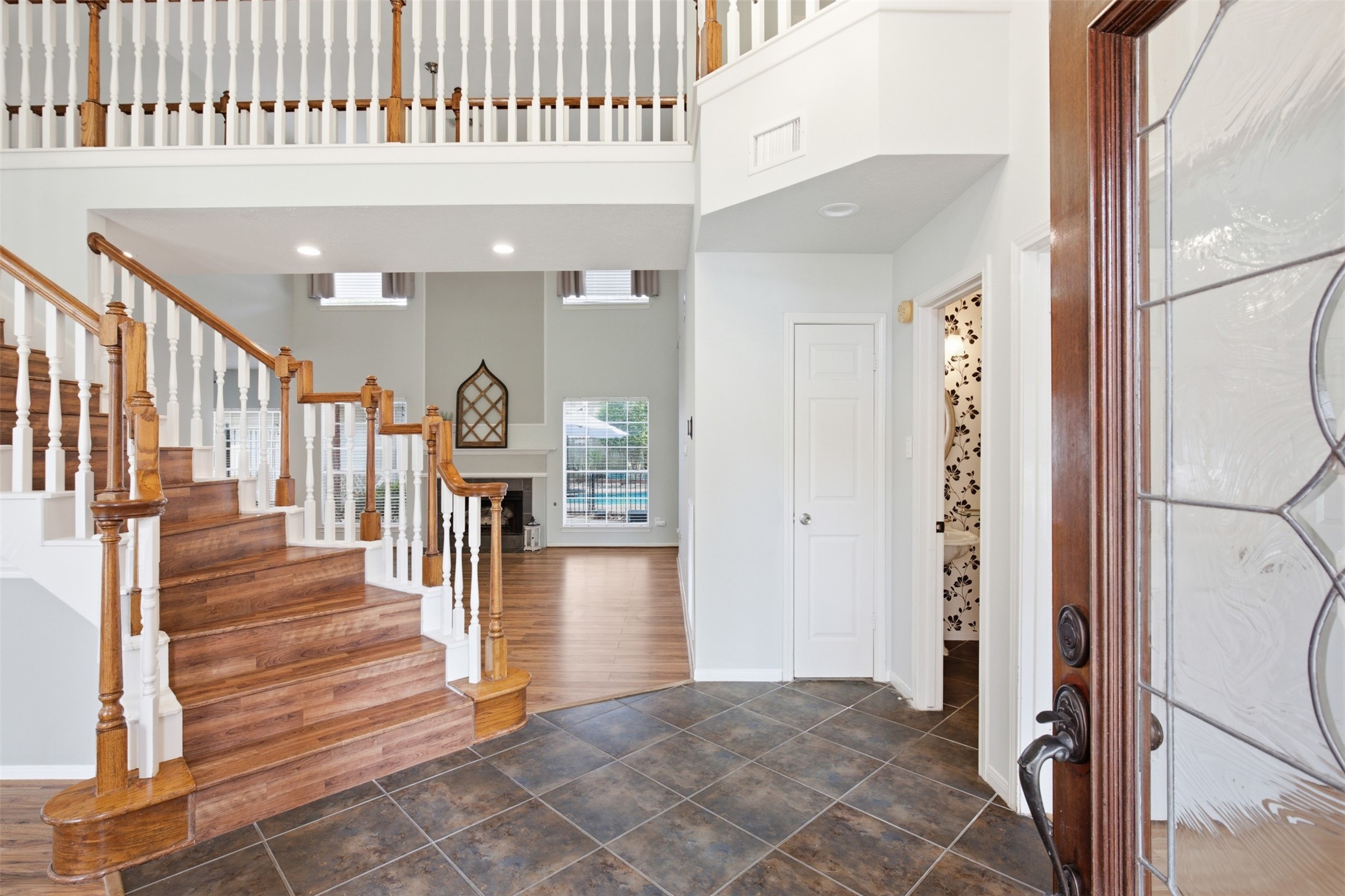 323 Magic Oaks Court Spring, TX 77388 - Photo 4 of 49 Look how inviting this beautiful entryway is! Through the front door, you can access the great room, gorgeous stairs to the second floor, a convenient bathroom, and a flexible sitting and gathering area with views of the front and side yards.