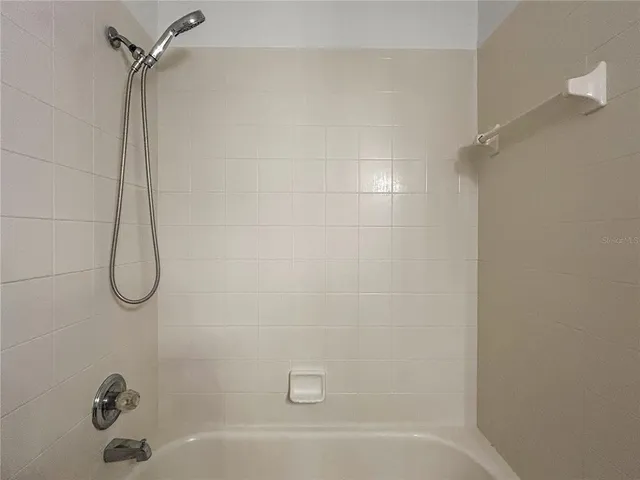 an empty room with wooden floor closet and windows