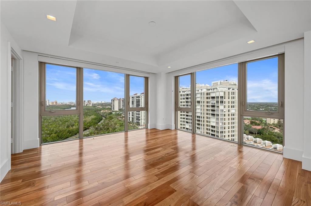6897 Grenadier Boulevard, Unit 1804 Naples, FL 34108 - Photo 15 of 30 a view of an empty room with wooden floor and a window