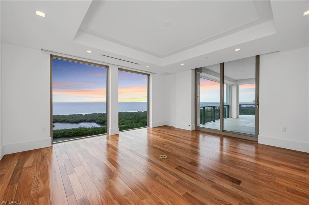 6897 Grenadier Boulevard, Unit 1804 Naples, FL 34108 - Photo 20 of 30 a view of an empty room with wooden floor and a window