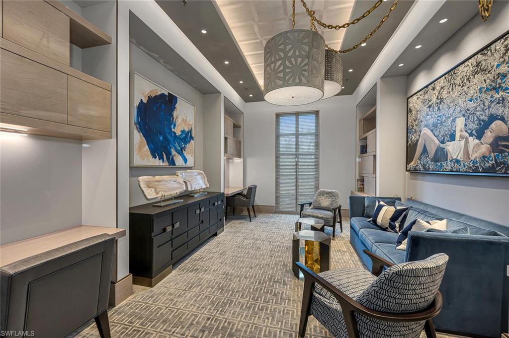 6897 Grenadier Boulevard, Unit 1804 Naples, FL 34108 - Photo 25 of 30 a living room with furniture a rug and wall paintings