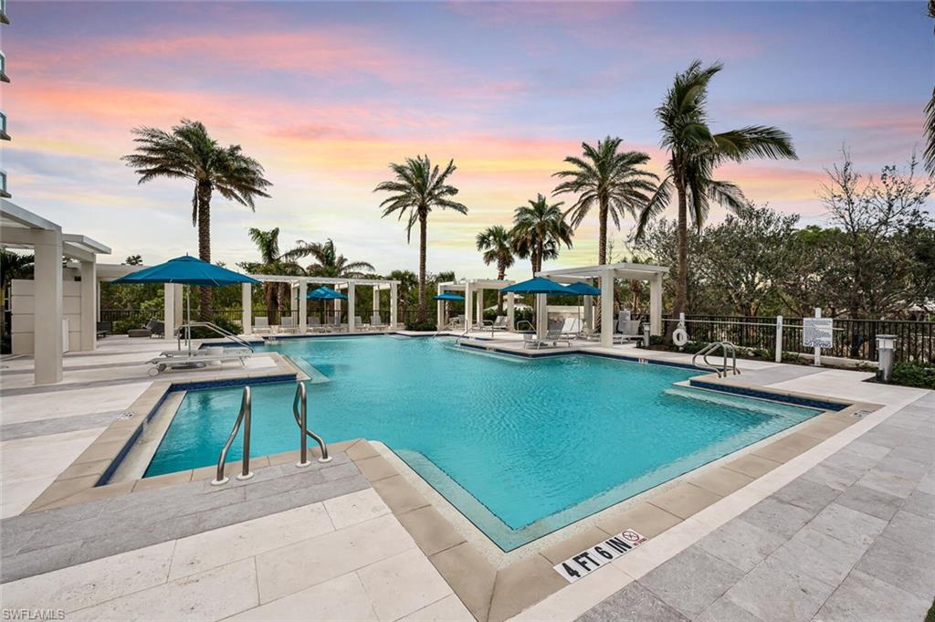 6897 Grenadier Boulevard, Unit 1804 Naples, FL 34108 - Photo 27 of 30 a view of a swimming pool with a table and chairs