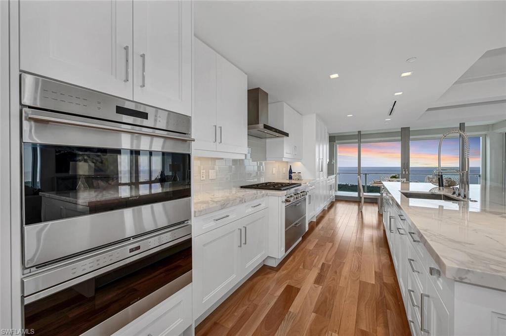 6897 Grenadier Boulevard, Unit 1804 Naples, FL 34108 - Photo 4 of 30 a kitchen with stainless steel appliances kitchen island granite countertop a stove and a sink