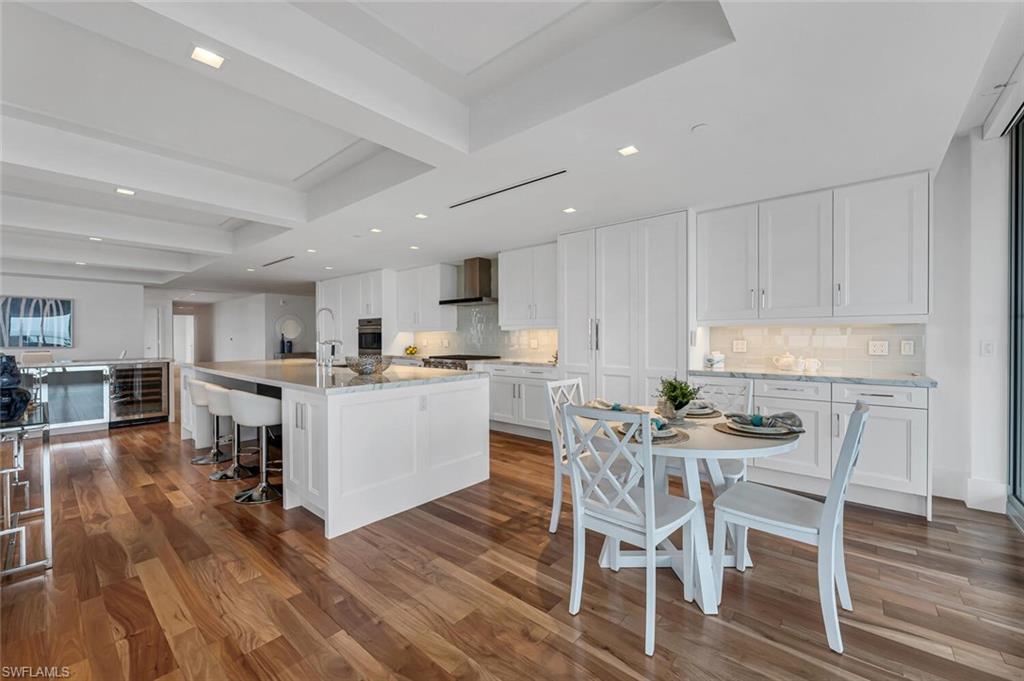 6897 Grenadier Boulevard, Unit 1804 Naples, FL 34108 - Photo 5 of 30 a kitchen with a dining table chairs and wooden floor