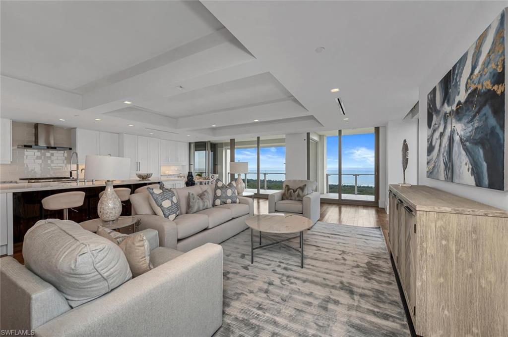 6897 Grenadier Boulevard, Unit 1804 Naples, FL 34108 - Photo 7 of 30 a living room with furniture and a table