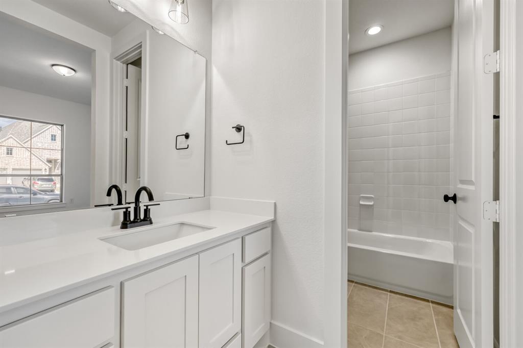 147 Derrett Lane Rhome, TX 76078 - Photo 22 of 28 Full bathroom with vanity, light tile patterned floors, and bathing tub / shower combination