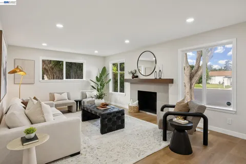 a living room with furniture a fireplace and a large window