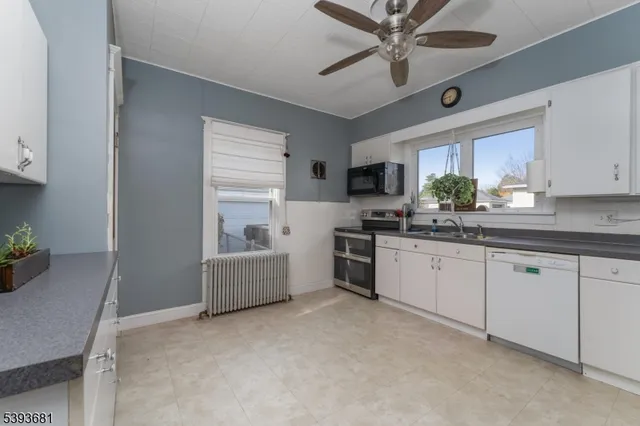 a kitchen with stainless steel appliances white cabinets and white appliances