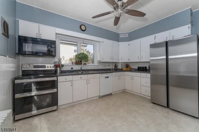 a kitchen with stainless steel appliances white cabinets and a sink