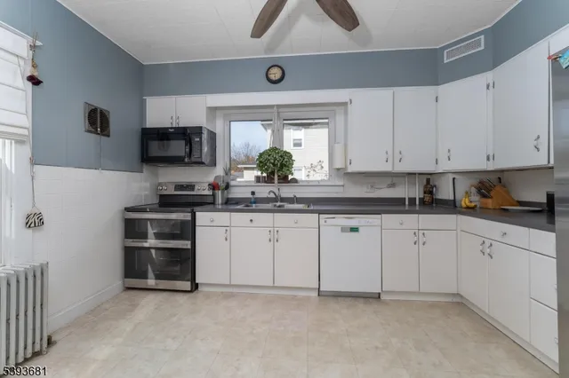 a dining room with furniture potted plants and wooden floor