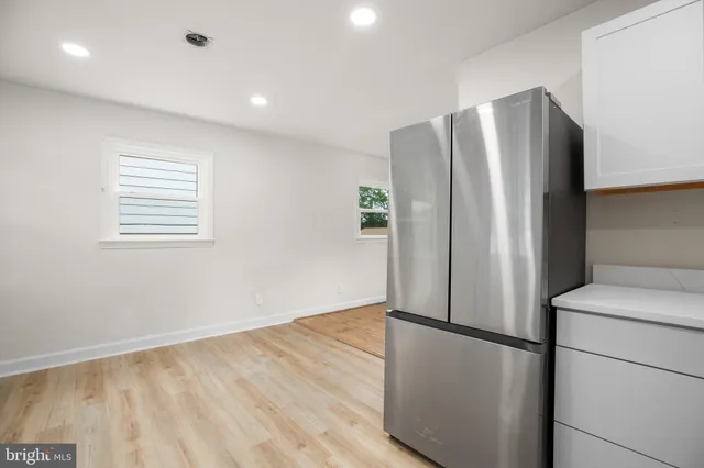 a view of a kitchen with a refrigerator and a stove top oven