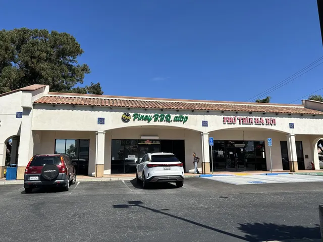 a front view of a building with retail shops and traffic signal