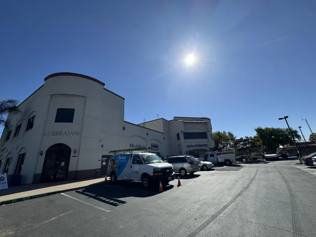 a view of a white house with a large tree