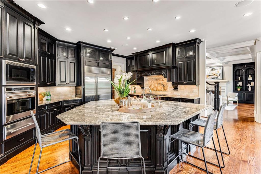 56 Mt Paran Road Northwest Atlanta, GA 30327 - Photo 12 of 52 a kitchen with stainless steel appliances kitchen island granite countertop a table chairs stove and refrigerator
