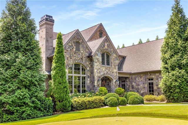 a front view of a house with a garden and plants