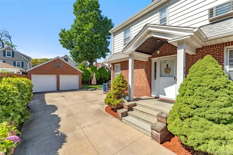 a front view of a house with a yard and potted plants