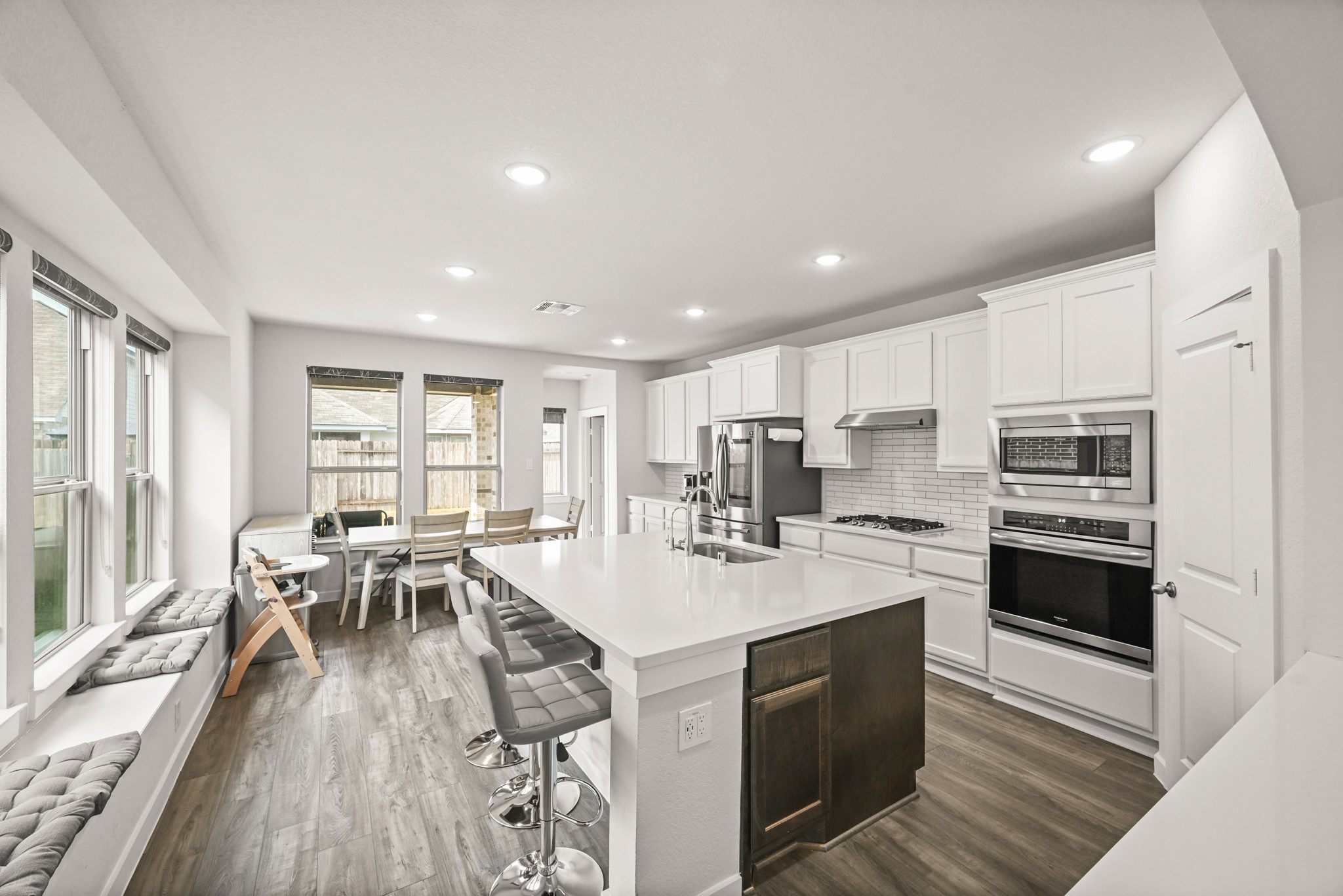 5010 Chestnut Orchard Drive Houston, TX 77066 - Photo 6 of 31 a kitchen with stainless steel appliances granite countertop a stove top oven a refrigerator a sink and white cabinets with wooden floor