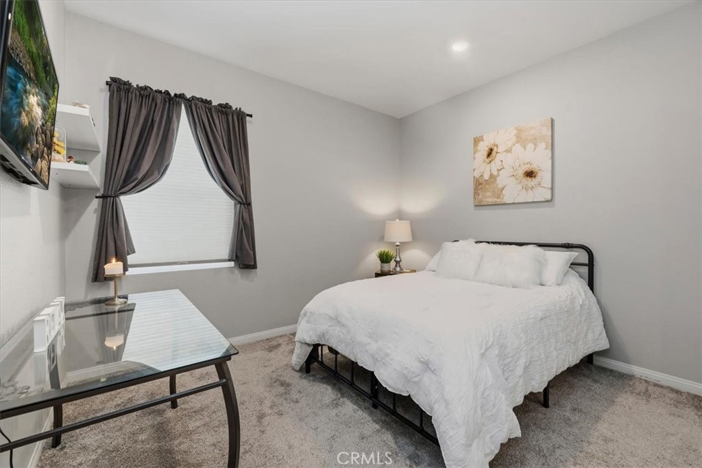 32937 Marin Fields Road Winchester, CA 92596 - Photo 25 of 47 a bedroom with a bed and a flat tv screen on the dresser