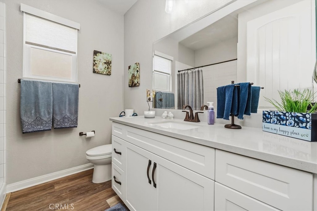 32937 Marin Fields Road Winchester, CA 92596 - Photo 26 of 47 a bathroom with a granite countertop sink a toilet and mirror