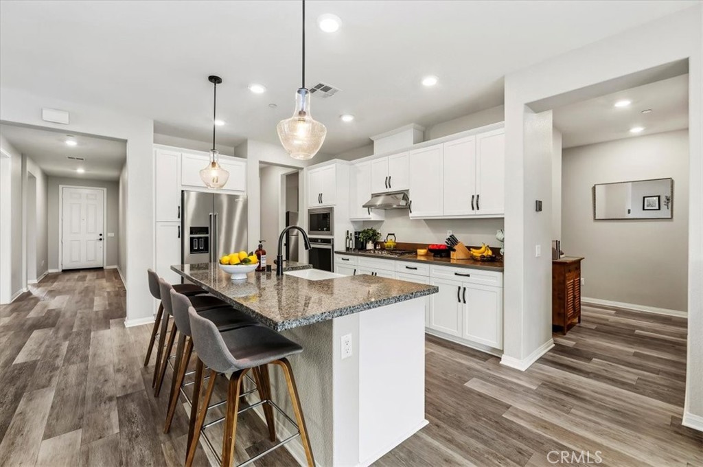 32937 Marin Fields Road Winchester, CA 92596 - Photo 9 of 47 a kitchen with kitchen island a dining table and chairs