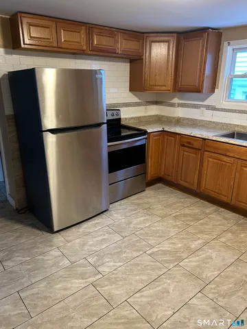 a kitchen with stainless steel appliances granite countertop a refrigerator sink and cabinets