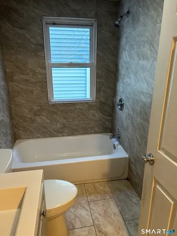 a bath tub sitting next to a blue sink and a window