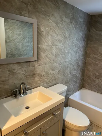 a bathroom with a sink a toilet and bathtub