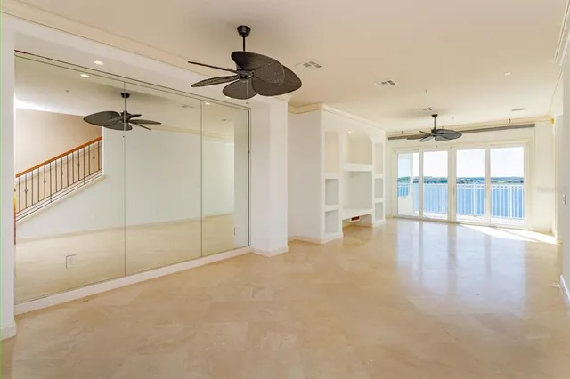 a view of empty room with wooden floor and fan
