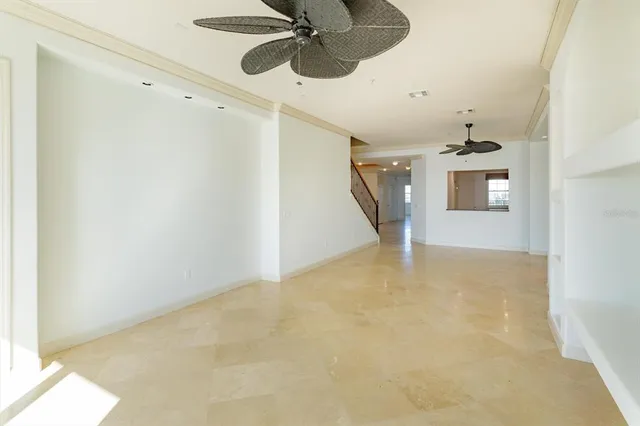 a view of a livingroom with a ceiling fan and stairs