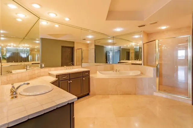 a bathroom with a granite countertop sink mirror and a bathtub