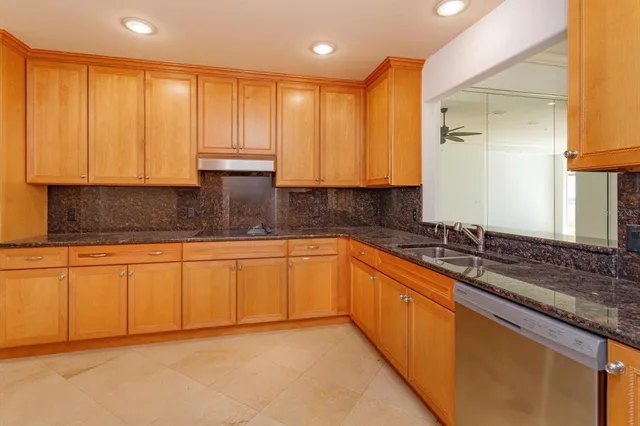 a kitchen with stainless steel appliances granite countertop a sink a stove cabinets and a granite counter top