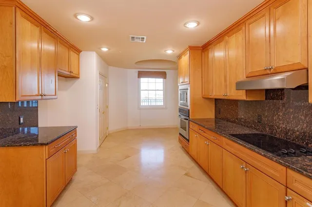 a kitchen with stainless steel appliances a sink stove and cabinets