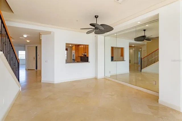 a view of a big room with a dining table and chandelier fan