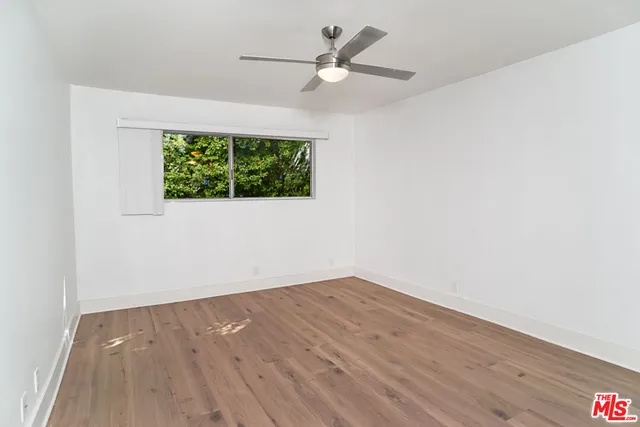 an empty room with wooden floor a ceiling fan and closet