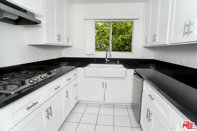 a kitchen with a sink a stove and cabinets