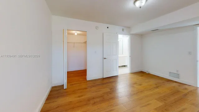 a view of an empty room with wooden floor