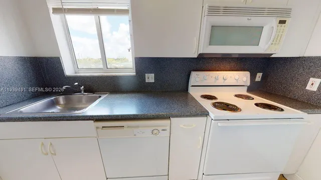 a kitchen with a sink stove and cabinets