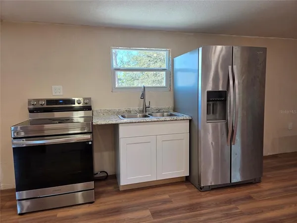 a kitchen with stainless steel appliances granite countertop a refrigerator sink and stove