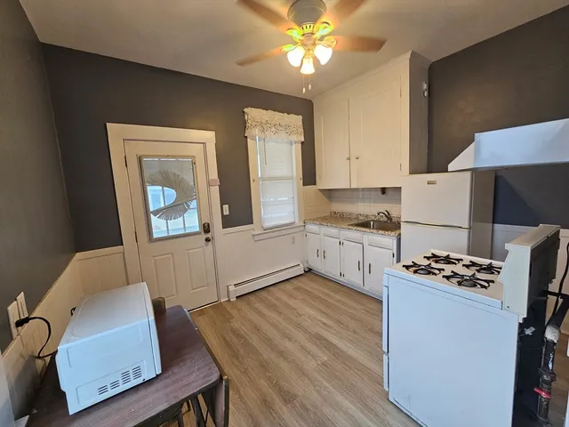 a kitchen with stainless steel appliances kitchen island granite countertop wooden cabinets a stove a sink and a refrigerator