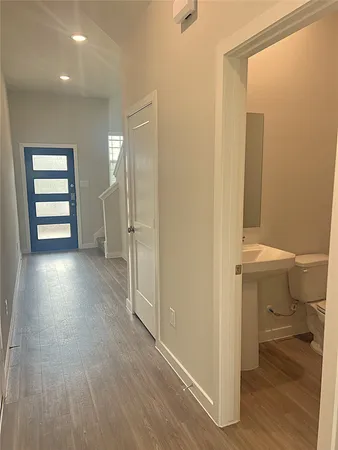 a view of a hallway and wooden floor and a bathroom