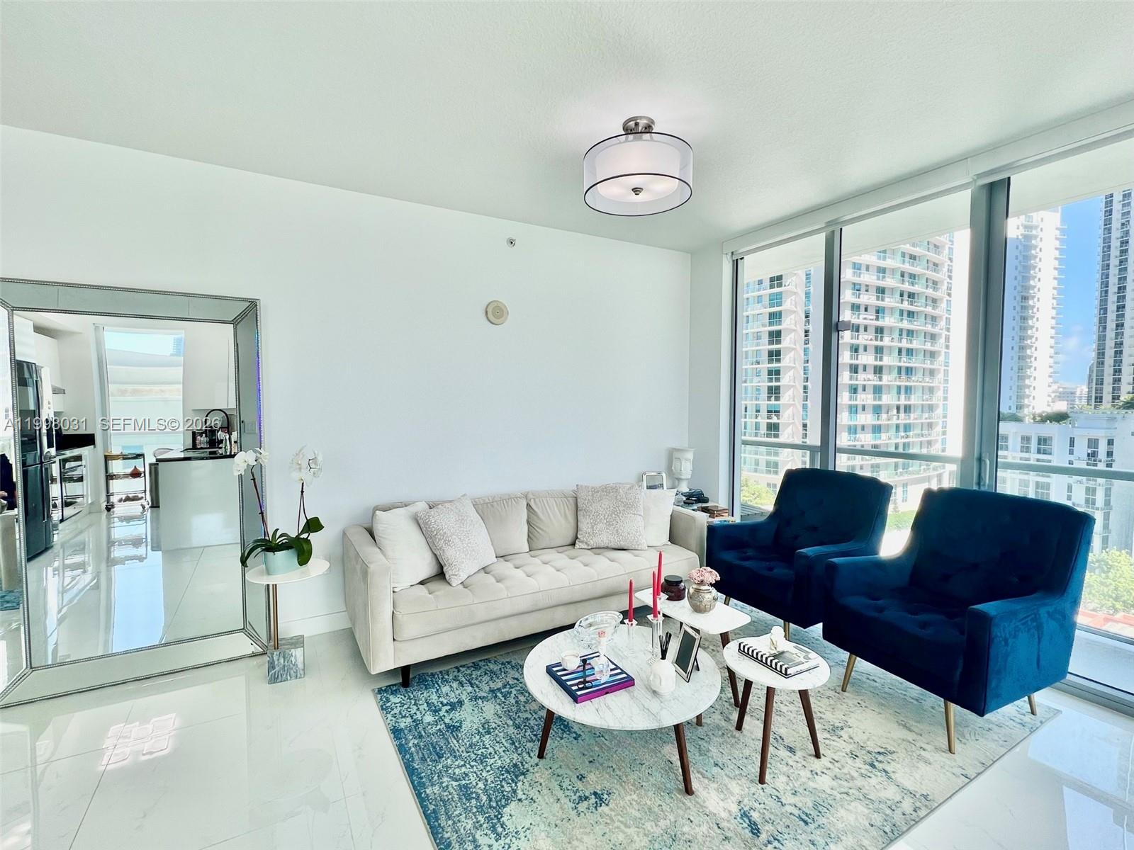 79 Southwest 12th Street, Unit 1806 Miami, FL 33130 - Photo 2 of 44 a living room with furniture and a large window