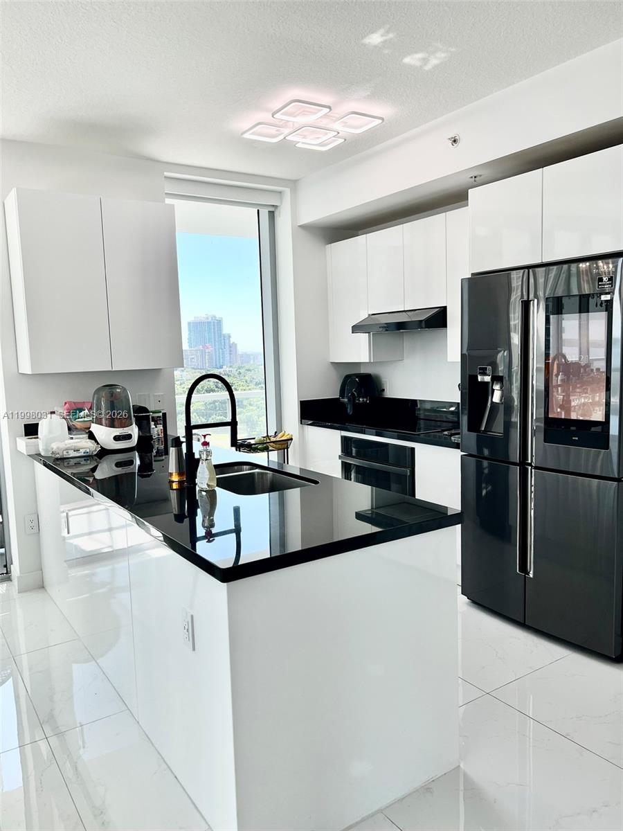 79 Southwest 12th Street, Unit 1806 Miami, FL 33130 - Photo 4 of 44 a kitchen with stainless steel appliances a sink a stove and cabinets