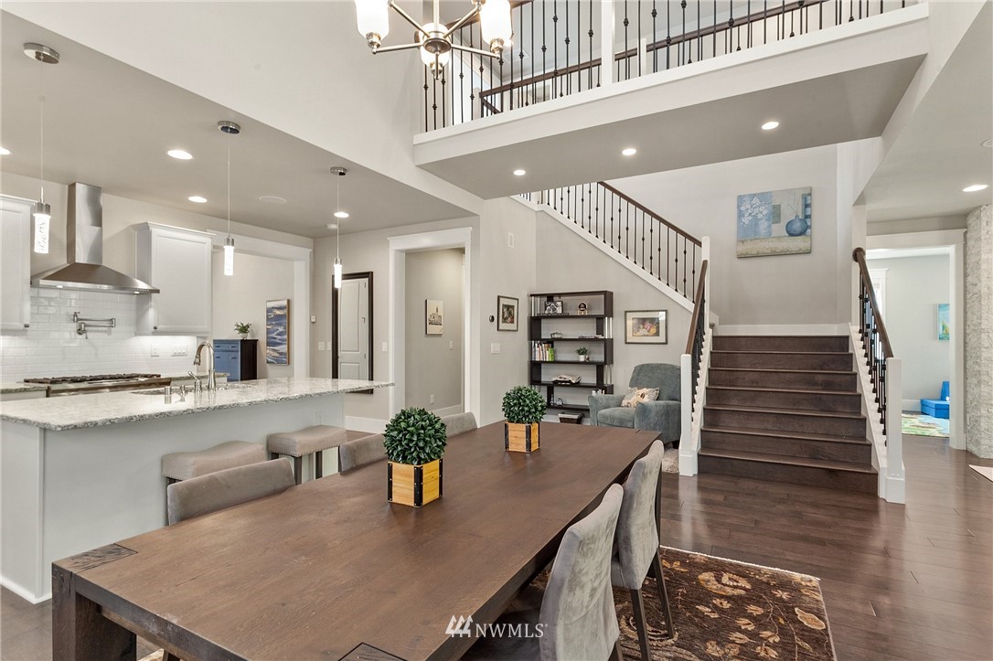 323 Field Place Southeast Renton, WA 98059 - Photo 11 of 40 a kitchen with stainless steel appliances kitchen island granite countertop a table chairs in it and wooden floors