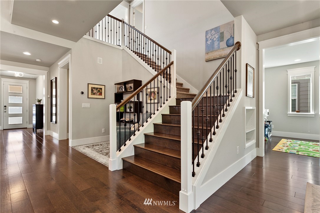 323 Field Place Southeast Renton, WA 98059 - Photo 16 of 40 a view of staircase with wooden floor and a chandelier
