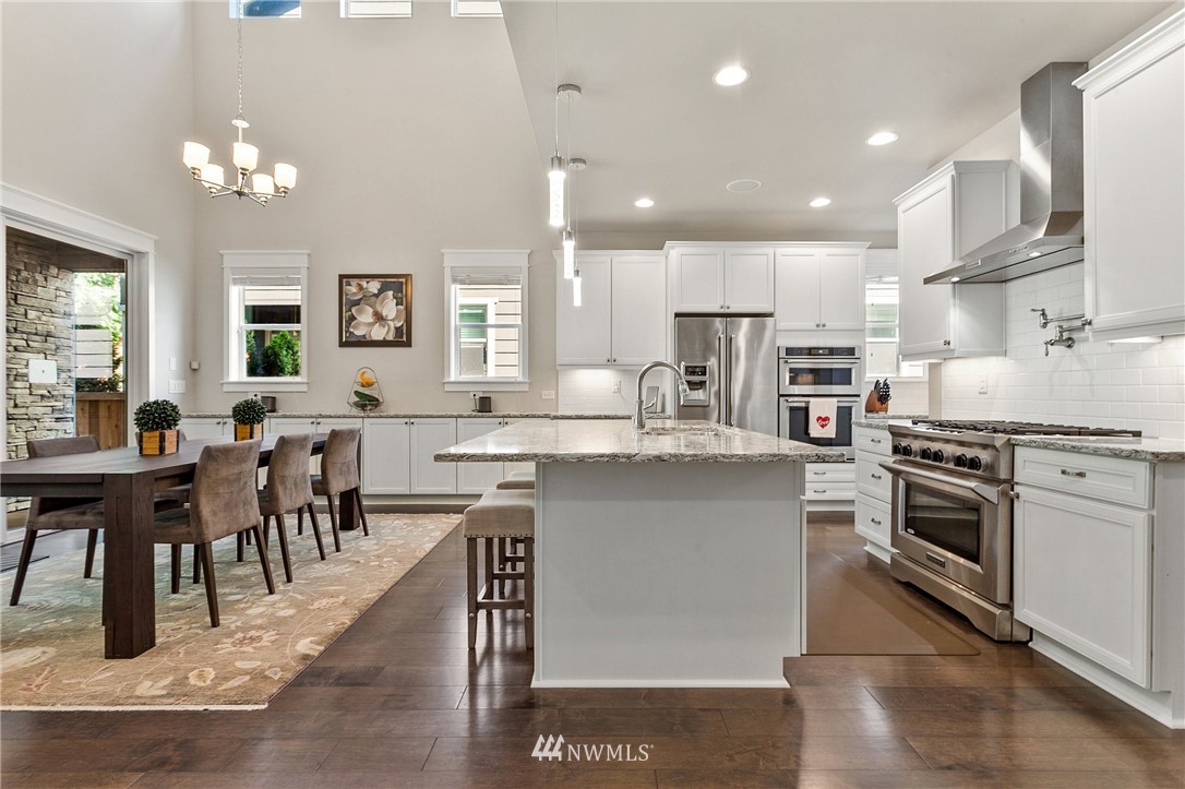 323 Field Place Southeast Renton, WA 98059 - Photo 5 of 40 a large kitchen with cabinets chairs and stainless steel appliances