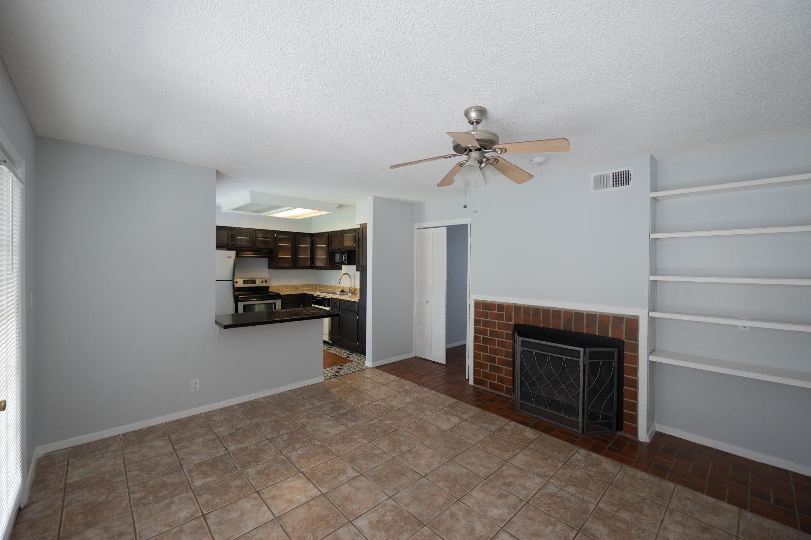 2110 Rio Grande Street, Unit 307 Austin, TX 78705 - Photo 3 of 12 An open concept living area seamlessly connects to the kitchen, featuring a fireplace with built-in shelving.