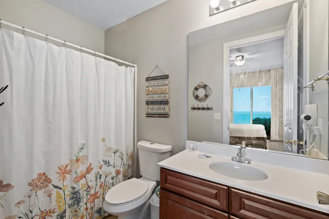 a bathroom with a sink a toilet and shower curtain