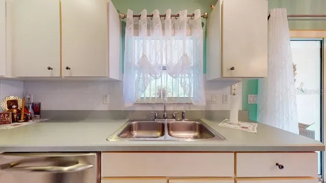 a kitchen with a sink cabinets and a window