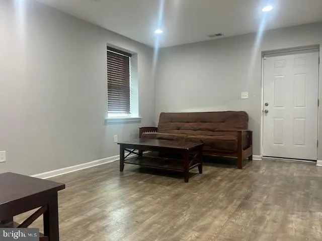 a living room with furniture a piano and a window