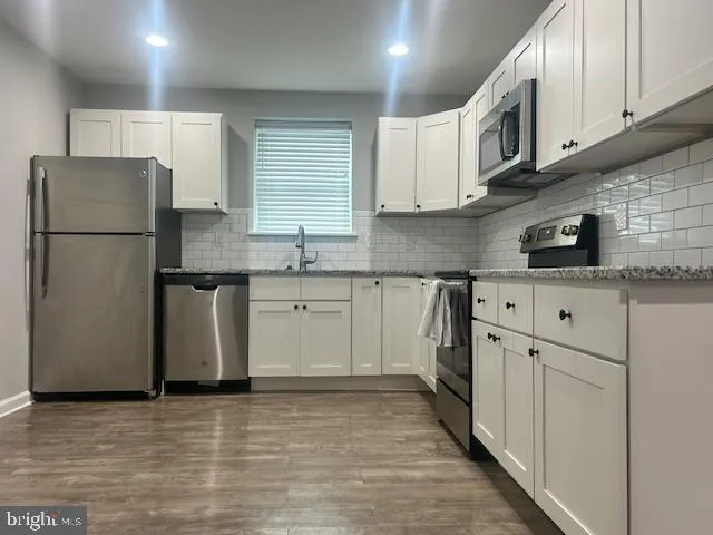 a kitchen with stainless steel appliances granite countertop a refrigerator sink and cabinets